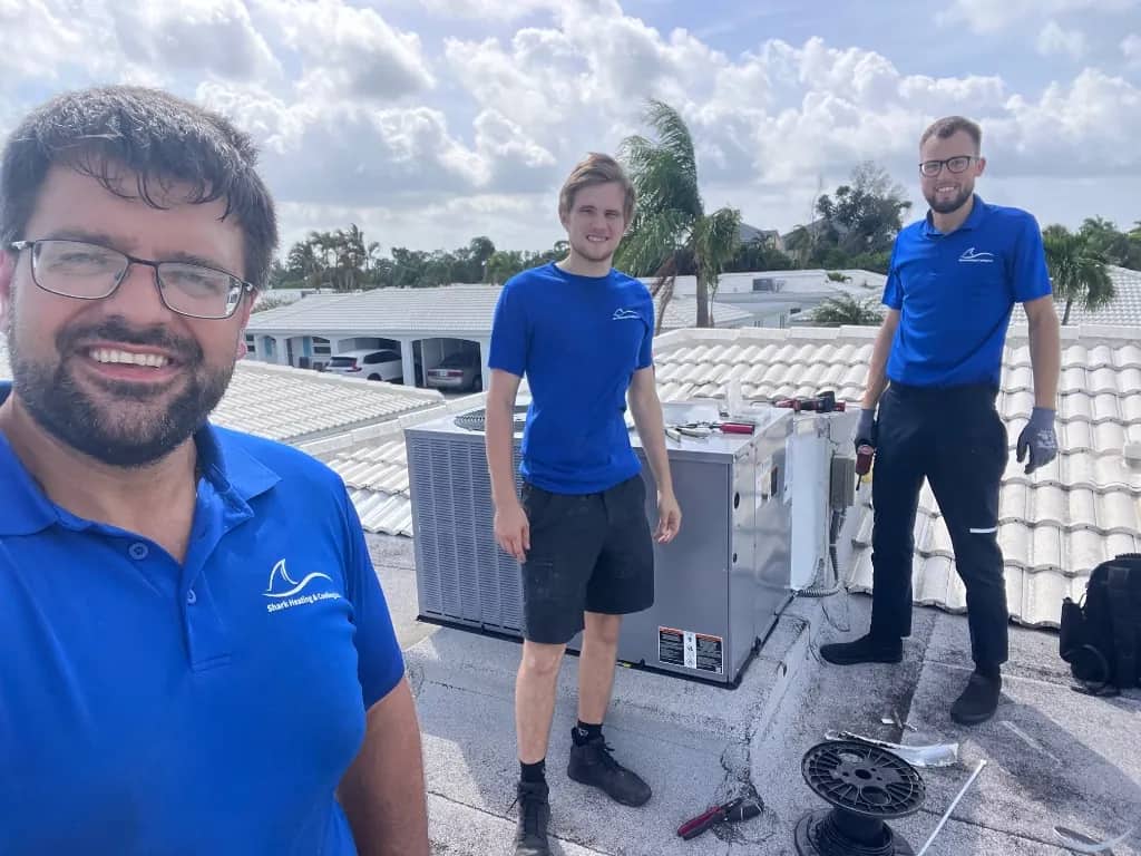 Shark Heating and Cooling team members working on a rooftop HVAC system